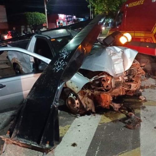 Motorista colide em moto, arranca semáforo e fica preso às ferragens